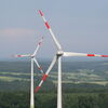 Zu sehen sind Windräder und eine unbebaute, hügelige Landschaft
