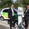 Dr. Sascha Meßmer übergibt Manfred Maile (r.) symbolisch die Ladekarten an der Ladestation vor dem Landschaftspark Wetzgau. 